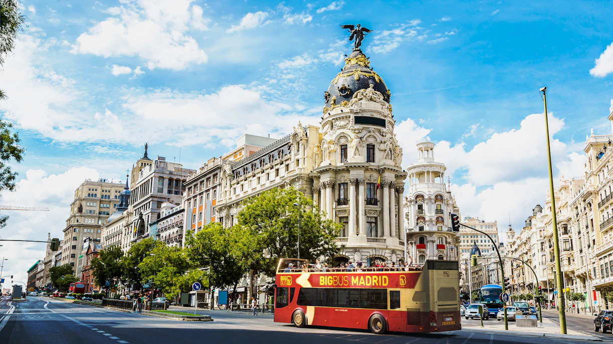 Big Bus Madrid tour passing by the Metropolis Building on Gran Via.