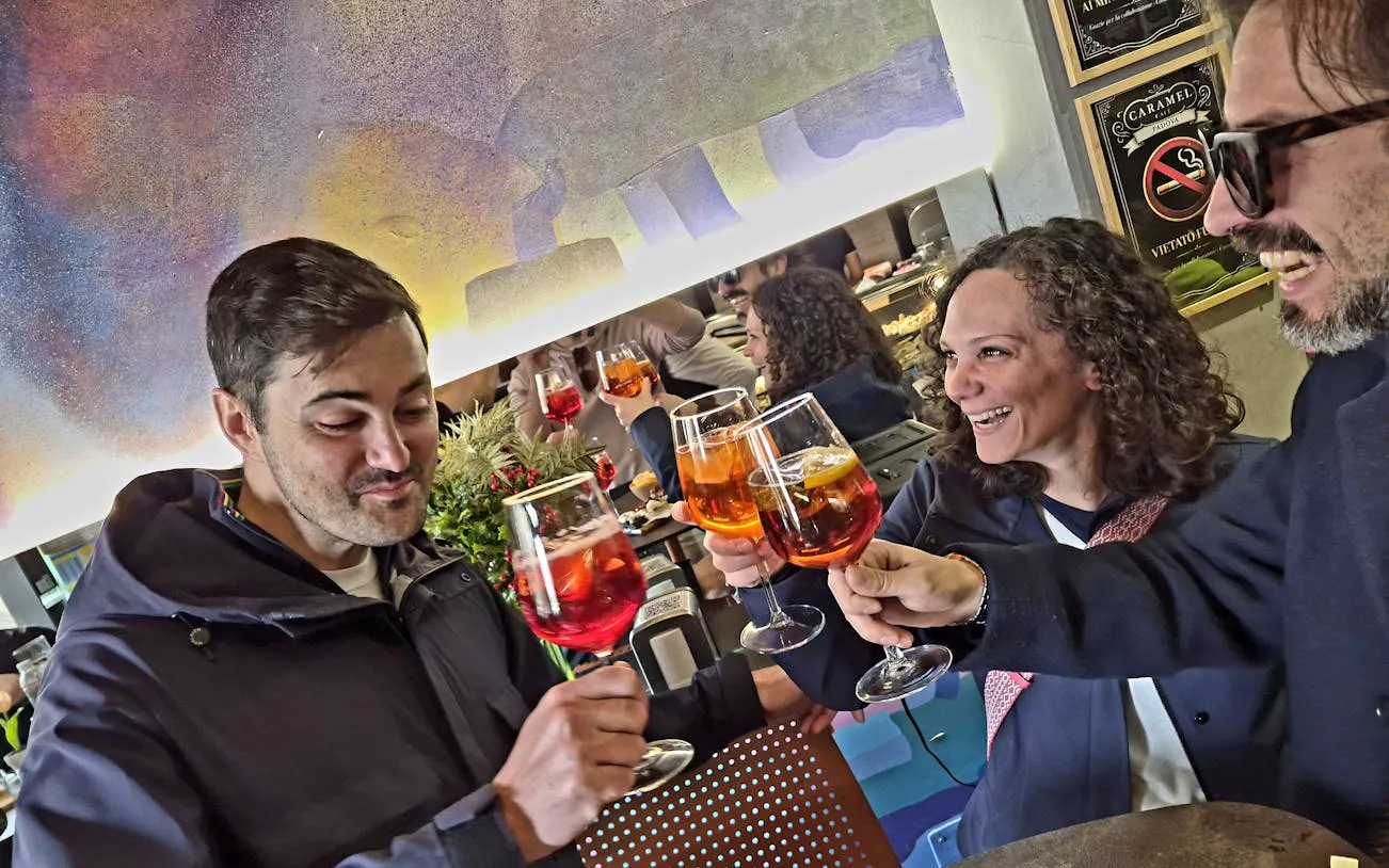 People toasting with glasses of wine during Padova Market to Osteria Food Tour.