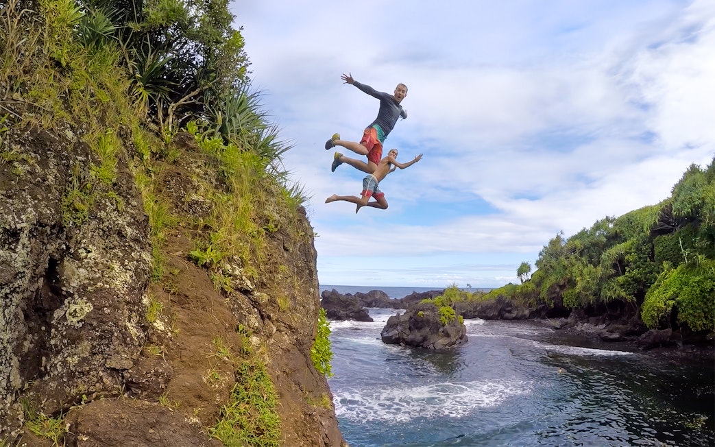 Cliff jumping into ocean on Road to Hana Tour, Maui, Hawaii.