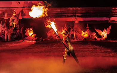 Fire performer at Yeepeng Lanna Festival 2023 with traditional decorations in the background.