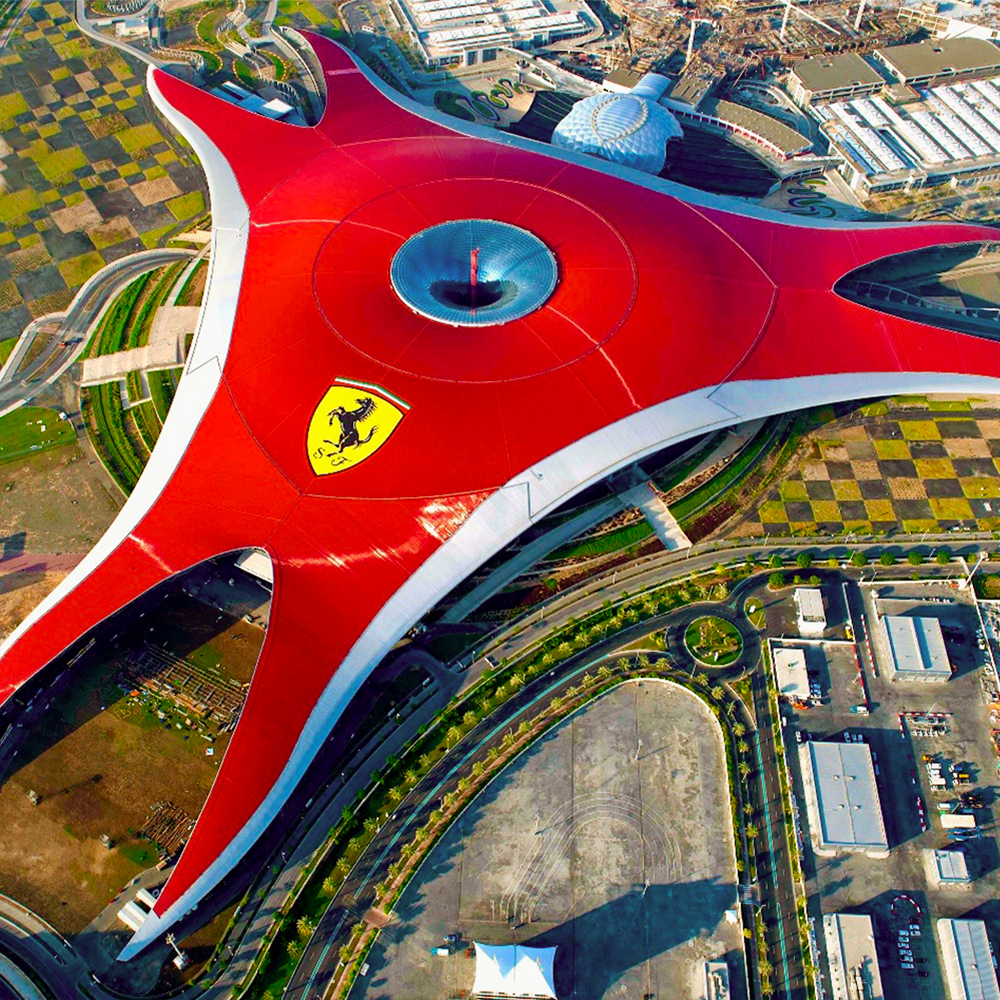Aerial view of Ferrari World Abu Dhabi's iconic red roof with Ferrari logo.