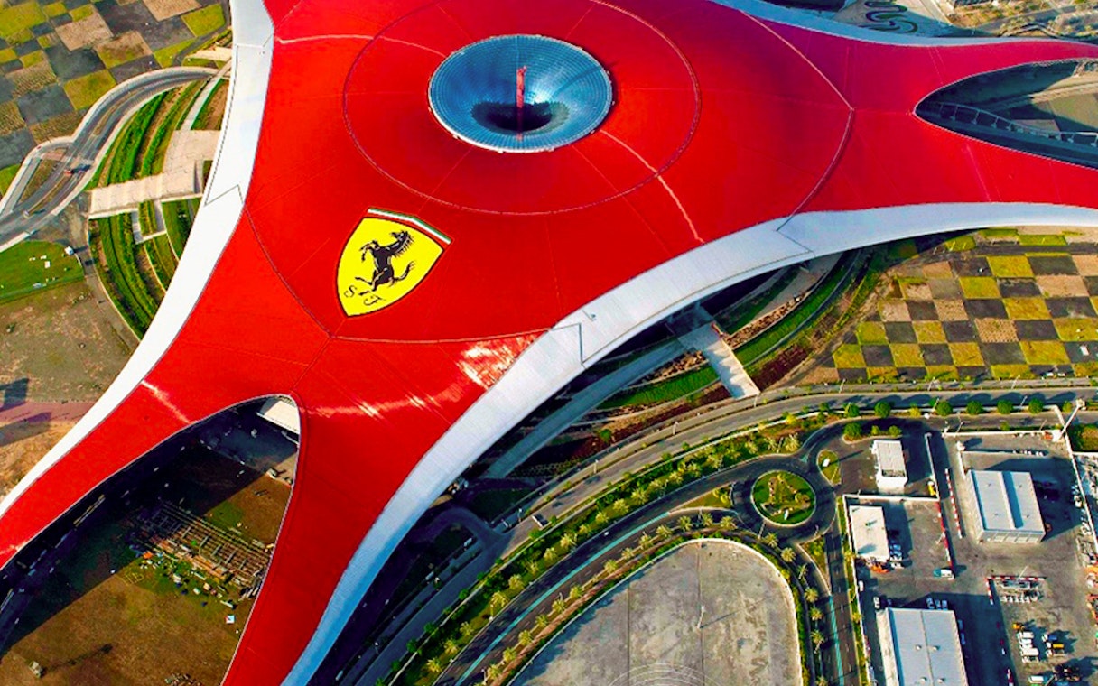 Aerial view of Ferrari World Abu Dhabi's iconic red roof with Ferrari logo.