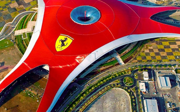 Aerial view of Ferrari World Abu Dhabi's iconic red roof with Ferrari logo.