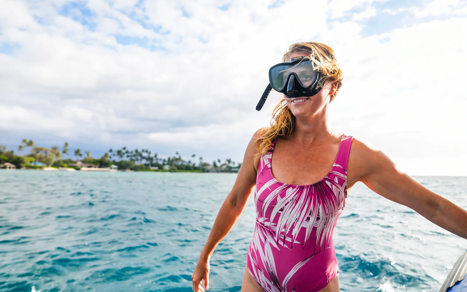 Woman preparing to snorkel on Big Island's Kohala Coast.