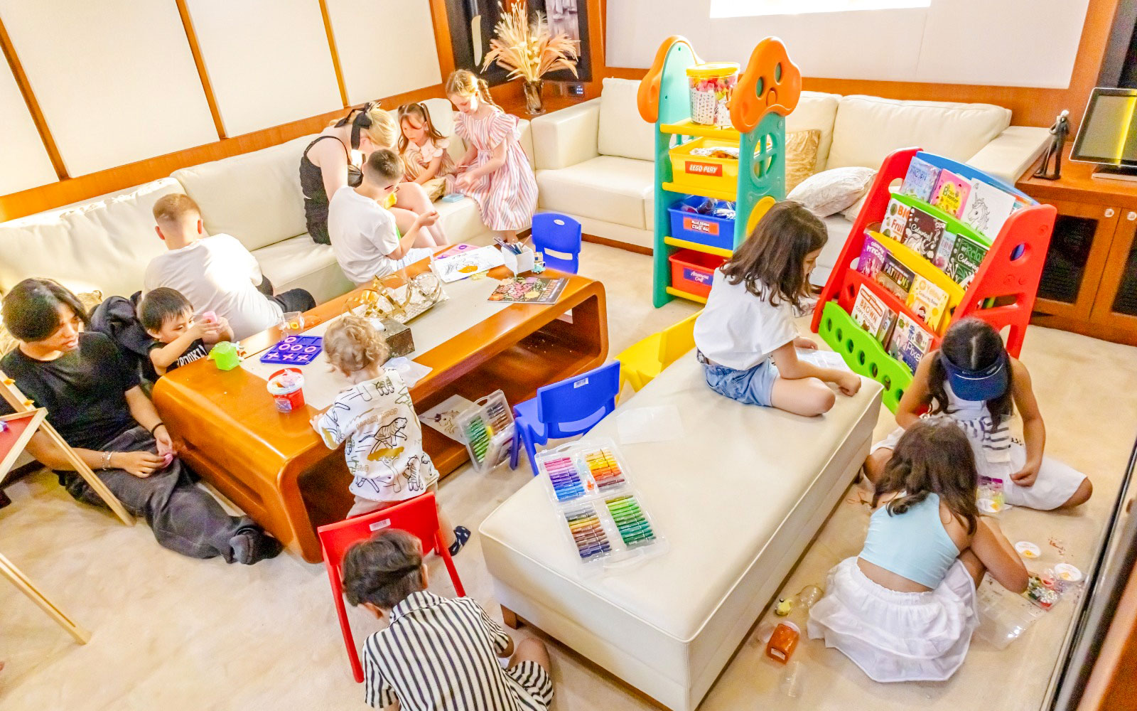 Children playing with toys and books on a yacht cruise in Dubai.