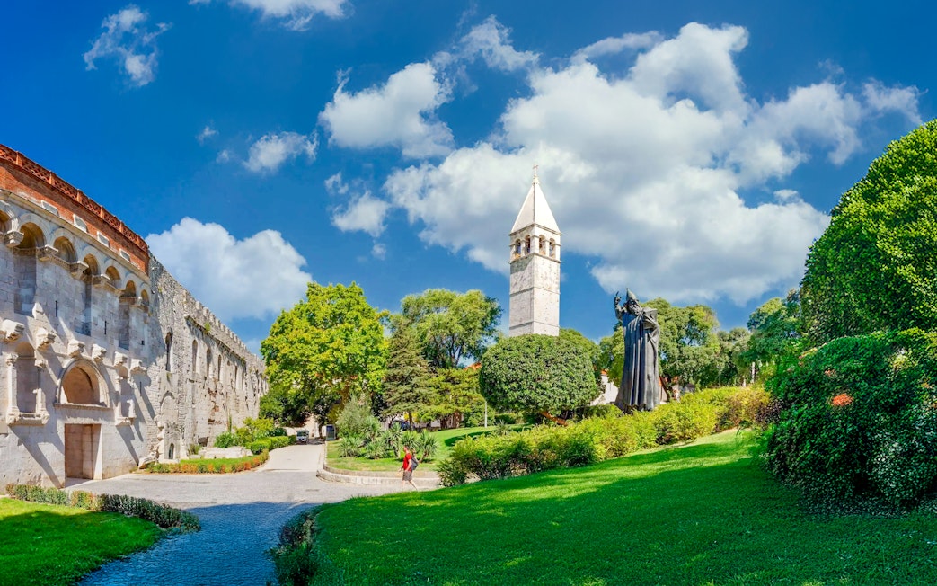 Diocletian's Palace walls and bell tower with statue in Split, Croatia.
