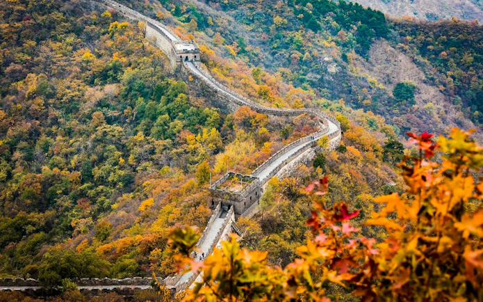 Mutianyu Great Wall winding through autumn foliage in Huairou District, Beijing.