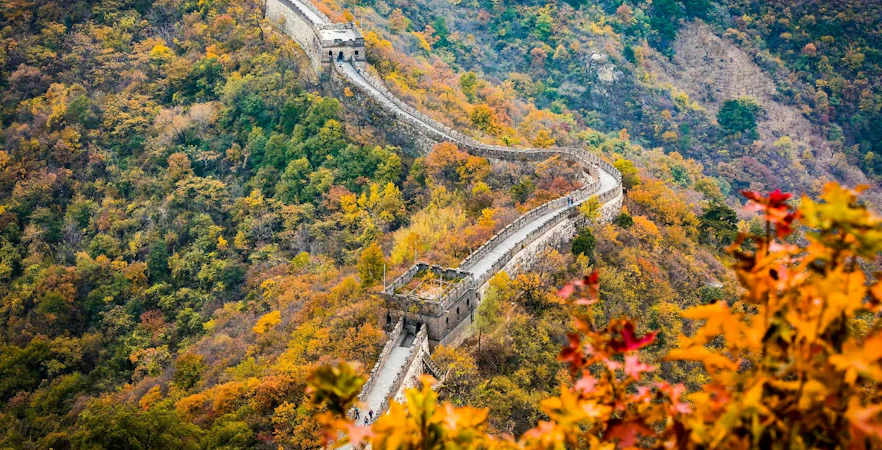 Mutianyu Great Wall winding through autumn foliage in Huairou District, Beijing.