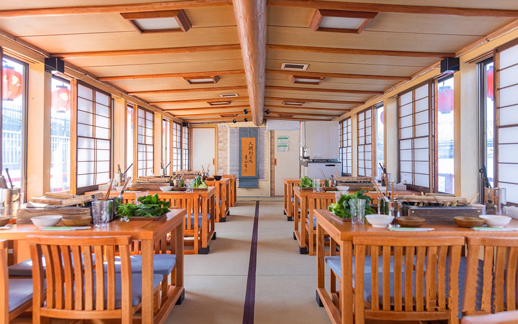 Yakatabune dining setup with tables prepared for hot pot dinner cruise in Japan.