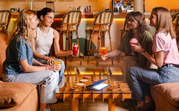 People enjoying drinks at Brasserie Auteuil in a cozy setting.