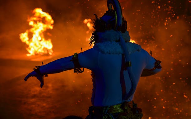 Uluwatu Kecak & Fire Dance Show performers in traditional Balinese attire at sunset, Bali, Indonesia.