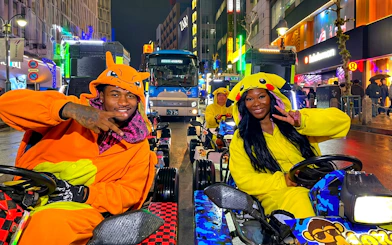 Go-kart riders in character costumes at Shibuya Crossing, Tokyo, during a night tour.