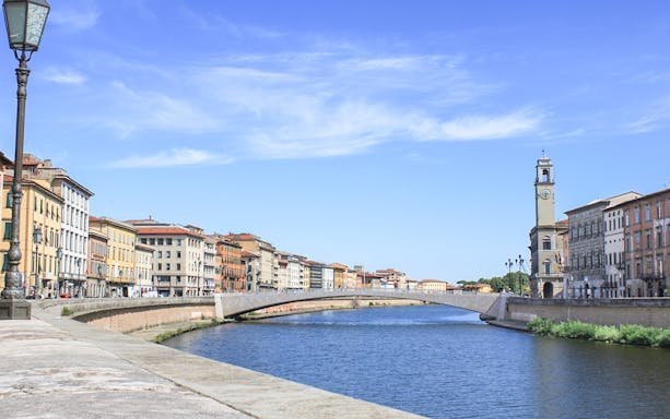 River Arno and historic buildings in Pisa, Italy, near the Leaning Tower tour.