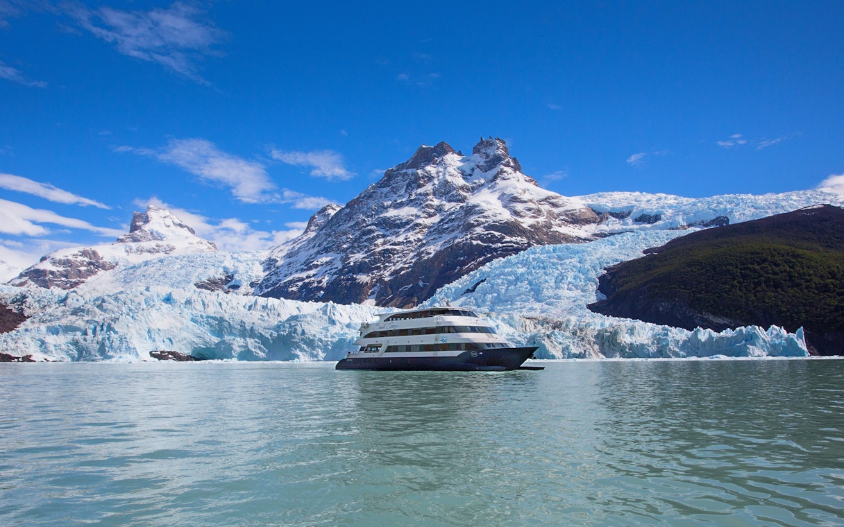 Boat cruising near glacier during Spirit of the Glaciers tour in Patagonia.