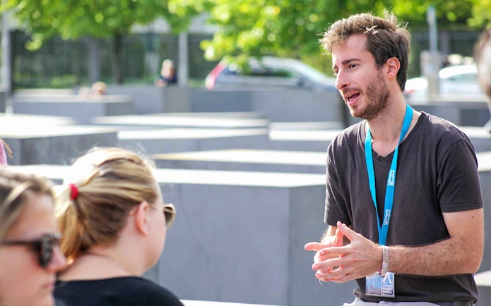 Guide explaining history during Berlin World War II walking tour.