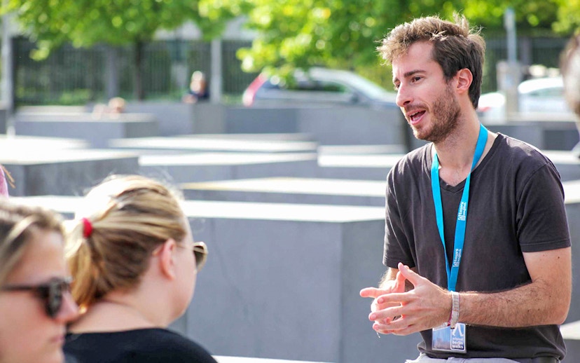 Guide explaining history during Berlin World War II walking tour.