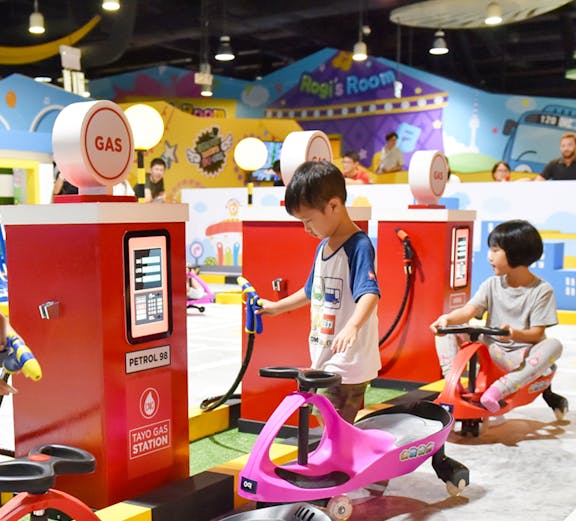 Children playing at Tayo Station gas station-themed ride.