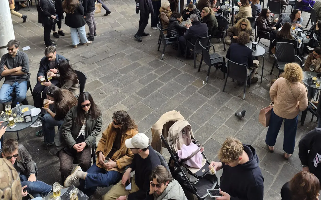 People enjoying drinks and conversation at an outdoor café in Padova during a food tour.