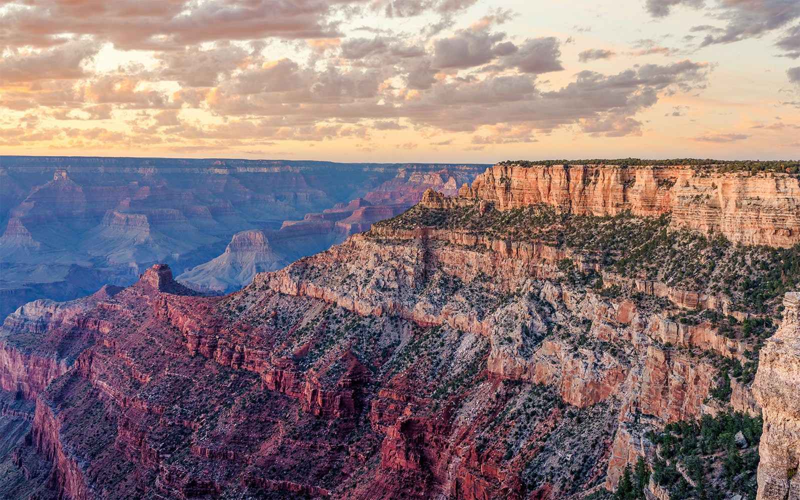 Sunset view of the Grand Canyon from Pipe Creek Vista, showcasing layered rock formations.