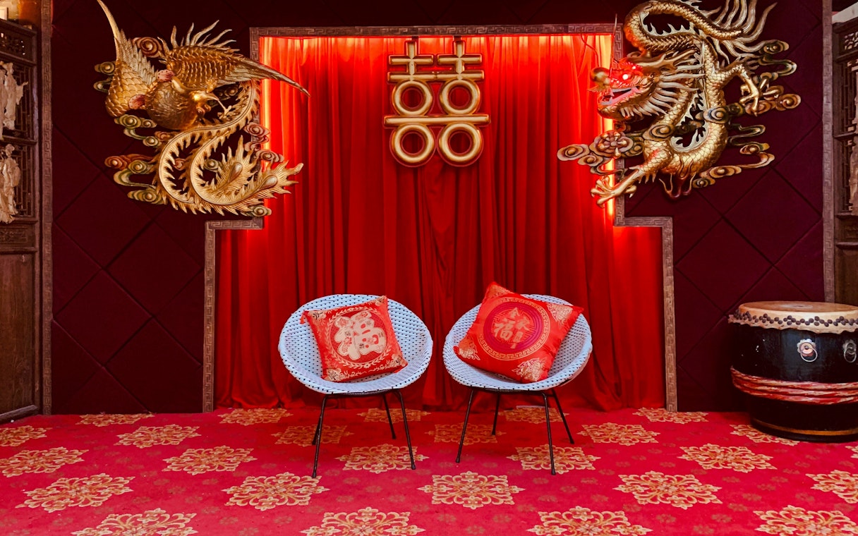 Interior decor with red curtains, gold dragon and phoenix, and chairs at Hong Kong Peak Tram & Sky Terrace.