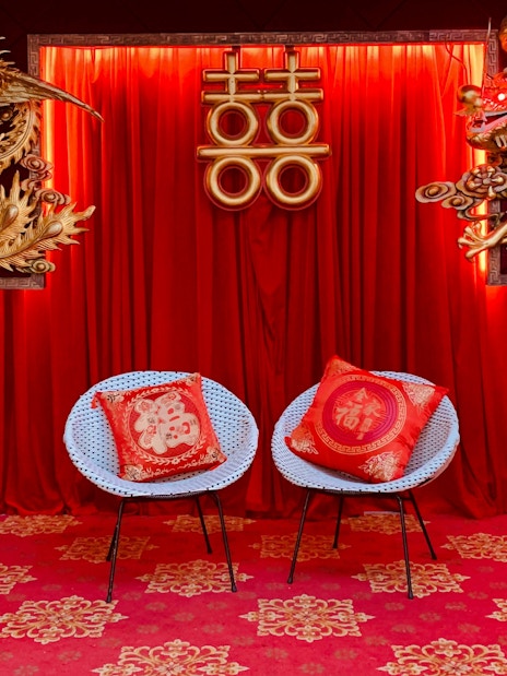 Interior decor with red curtains, gold dragon and phoenix, and chairs at Hong Kong Peak Tram & Sky Terrace.