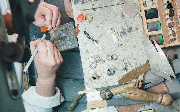 Artisan crafting jewelry at a workbench in Ortigia, Siracusa.