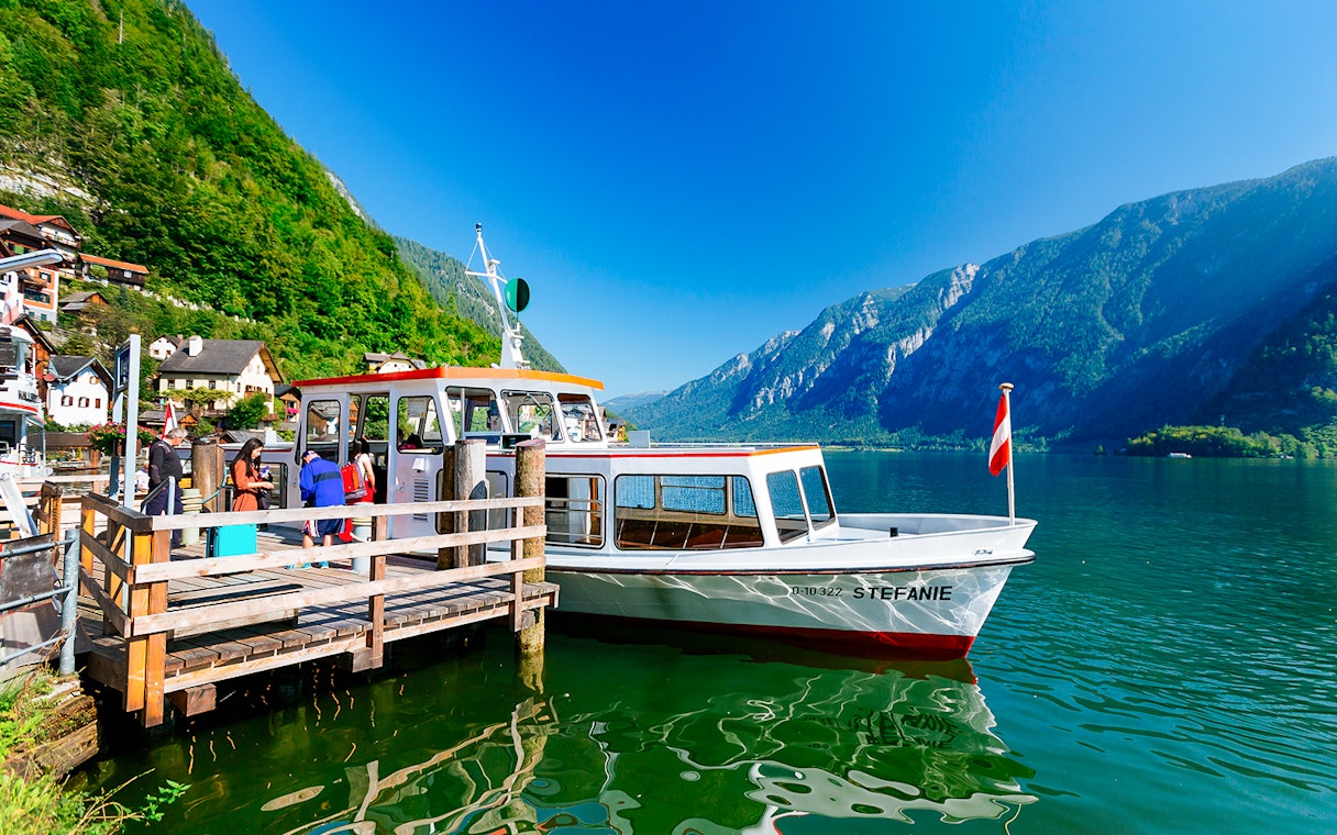 Boat docked at Hallstatt lake with mountains in the background, part of Vienna day trip.