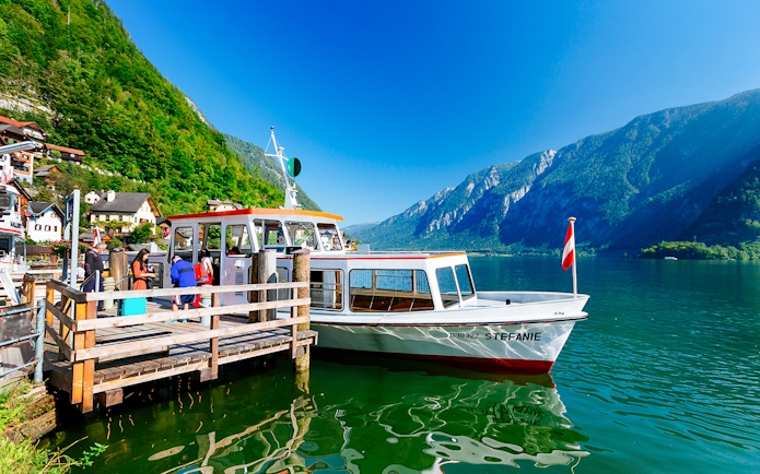 Boat docked at Hallstatt lake with mountains in the background, part of Vienna day trip.
