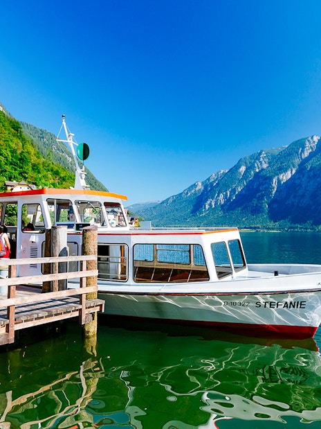 Boat docked at Hallstatt lake with mountains in the background, part of Vienna day trip.