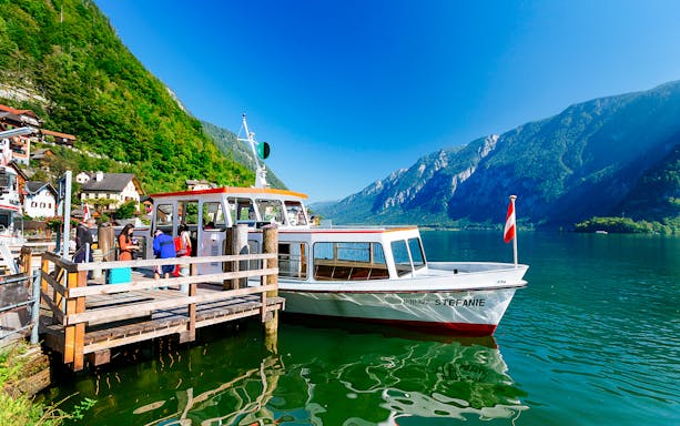 Boat docked at Hallstatt lake with mountains in the background, part of Vienna day trip.