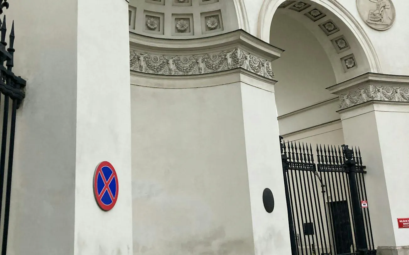 Warsaw city gate with ornate arch and no parking sign, part of self-guided mystery tour.