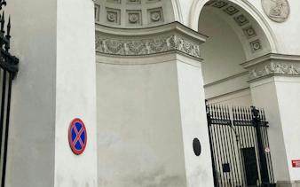 Warsaw city gate with ornate arch and no parking sign, part of self-guided mystery tour.