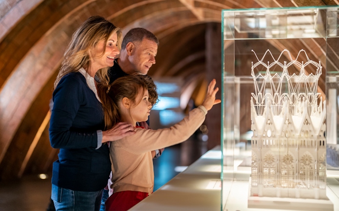 Visitors observing architectural model at La Pedrera-Casa Milà, Barcelona.
