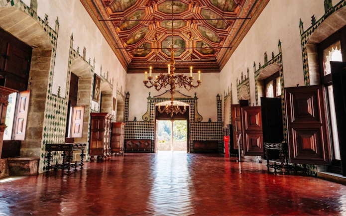 Interior of the National Palace of Sintra with ornate ceiling and open doors.