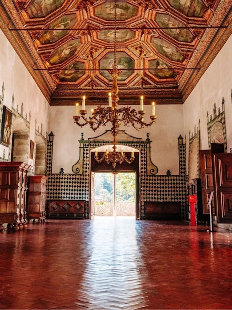 Interior of the National Palace of Sintra with ornate ceiling and open doors.