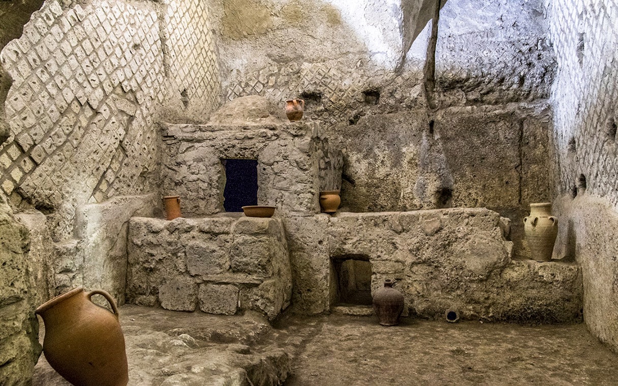 Underground ruins with ancient pottery in Naples city tour.