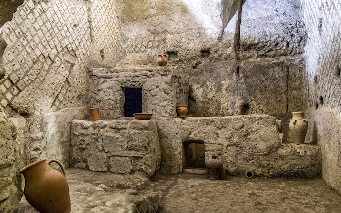 Underground ruins with ancient pottery in Naples city tour.