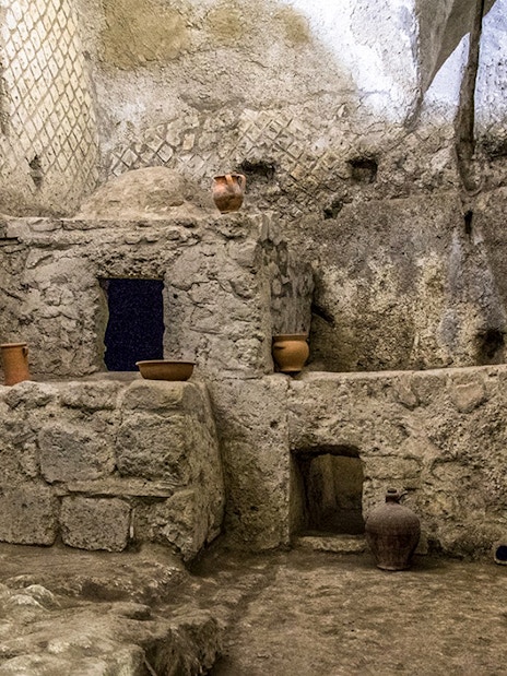 Underground ruins with ancient pottery in Naples city tour.