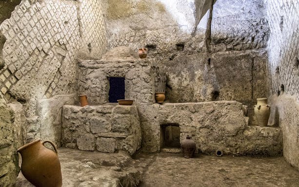 Underground ruins with ancient pottery in Naples city tour.