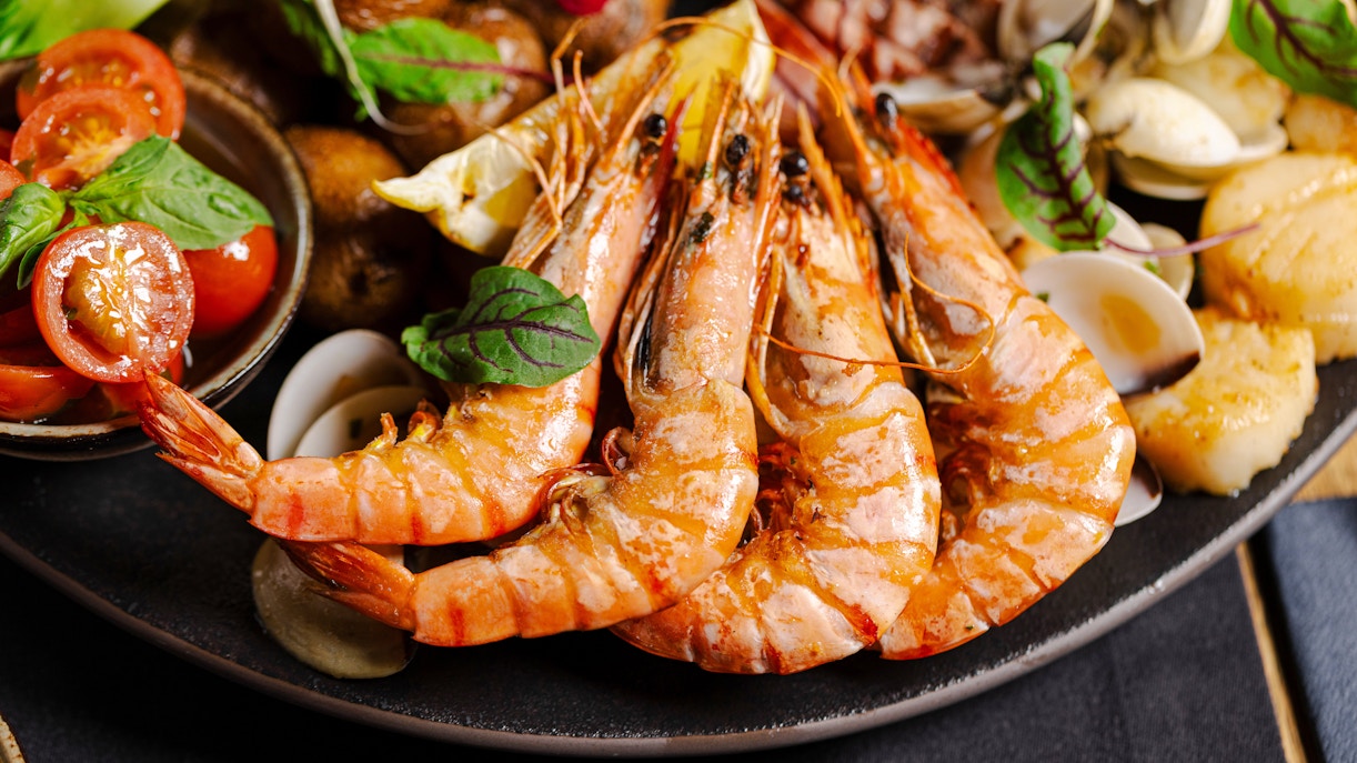 Seafood platter with prawns, clams, and cherry tomatoes.