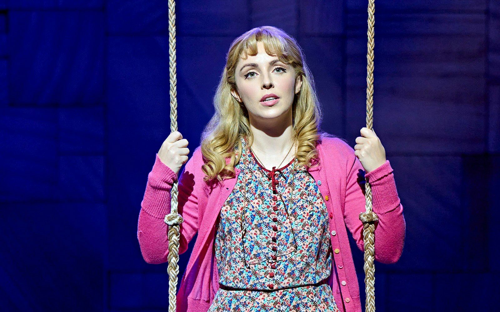 Performer on stage in Matilda The Musical holding a swing rope.