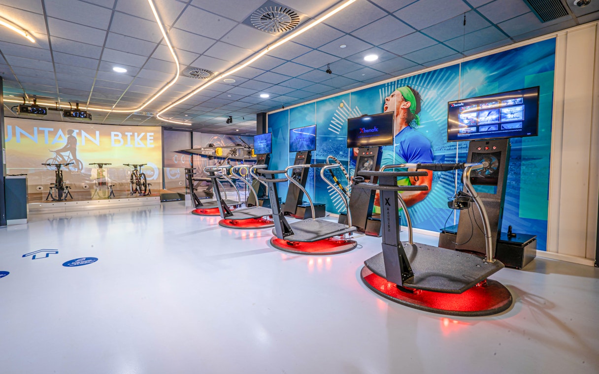 Interactive exhibits at Rafa Nadal Museum Xperience featuring cycling and sports simulators.