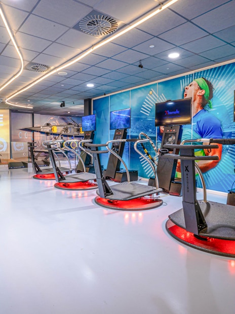Interactive exhibits at Rafa Nadal Museum Xperience featuring cycling and sports simulators.