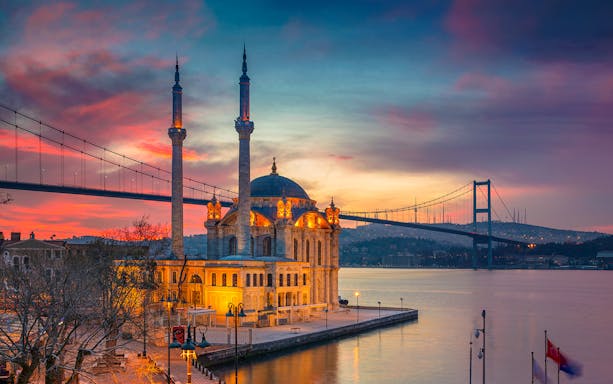 Ortaköy Mosque at sunset with Bosphorus Bridge in Istanbul.