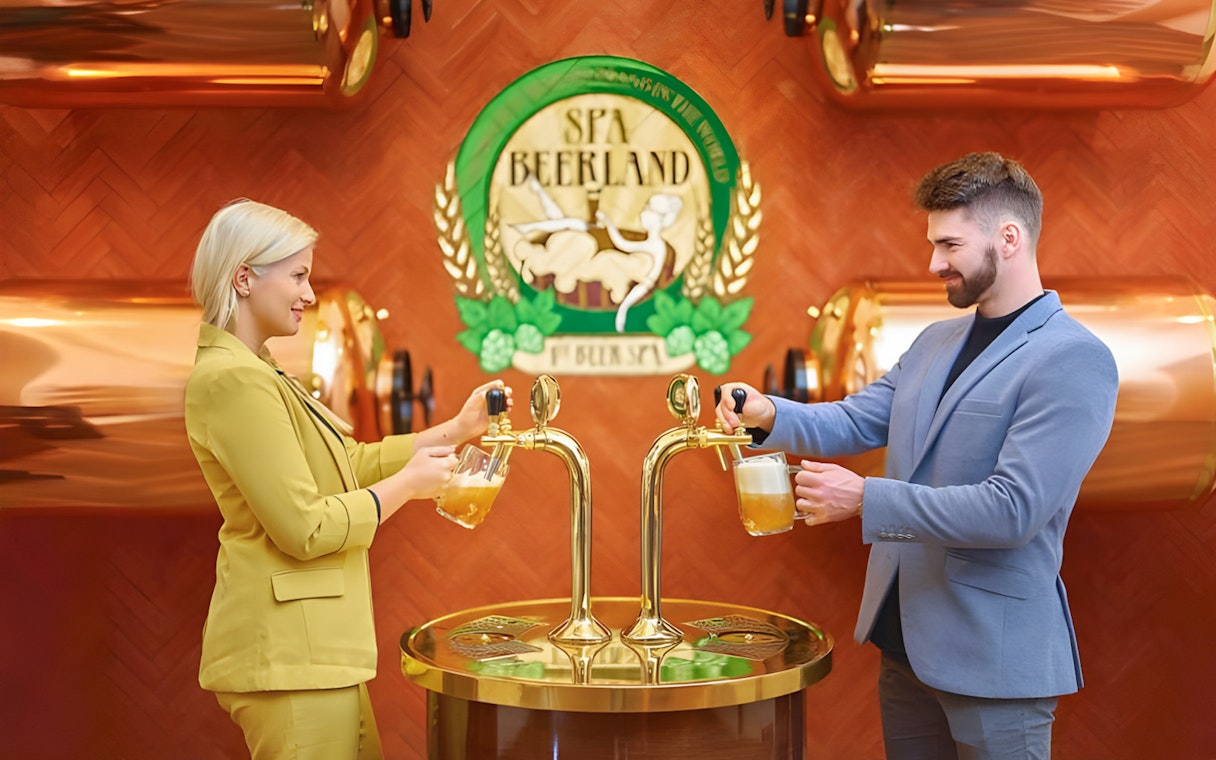 Guests pouring beer at Spa Beerland taps with logo in background.