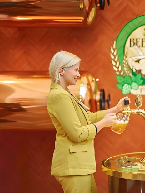 Guests pouring beer at Spa Beerland taps with logo in background.