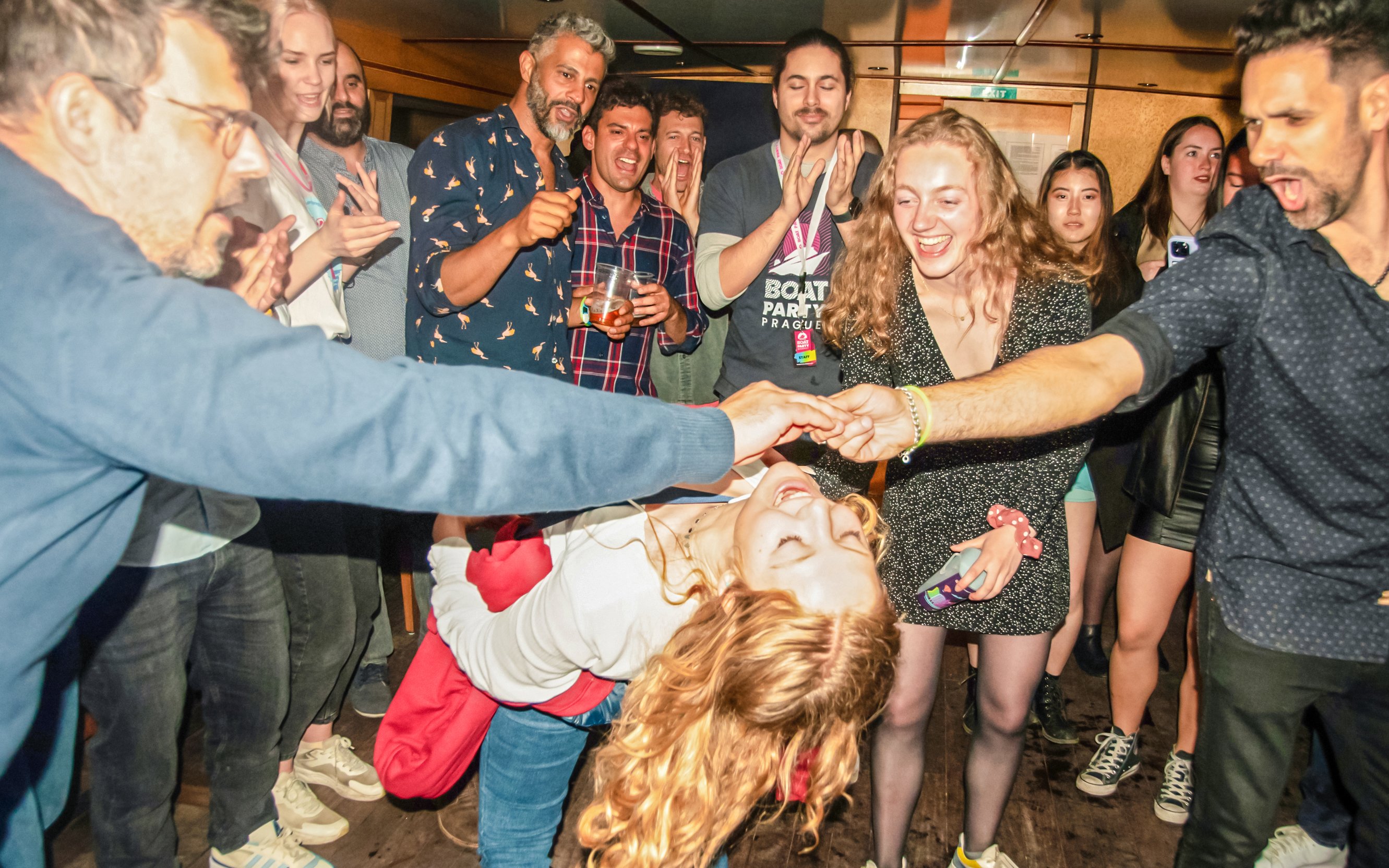 Guests enjoying a lively dance at a sunset boat party in Prague.