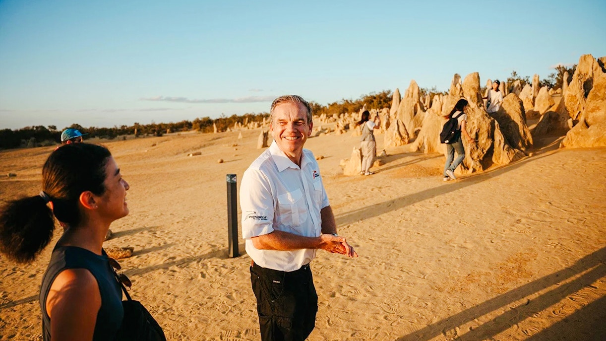 Tour guide leading visitors through Pinnacles Desert at sunset, Western Australia.