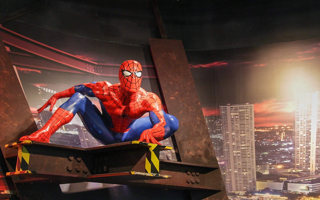Spider-Man figure at Madame Tussauds Bangkok with cityscape backdrop.