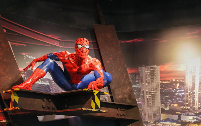 Spider-Man figure at Madame Tussauds Bangkok with cityscape backdrop.
